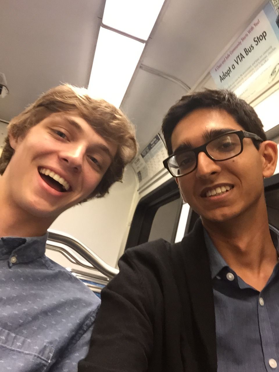 Cameron and Jamil grinning on the San Jose light rail, 2015